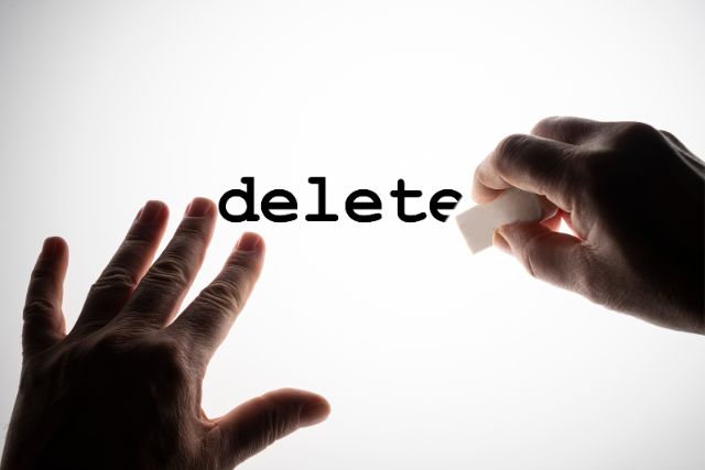 The word 'delete' on a white background, with a hand erasing the word, symbolizing content pruning.